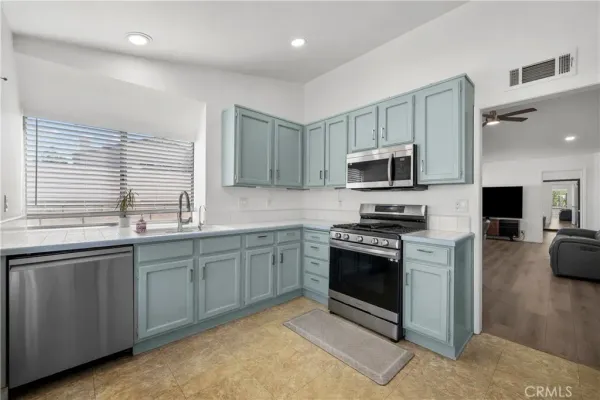 a kitchen with stainless steel appliances granite countertop a stove top oven a sink dishwasher a dining table and chairs