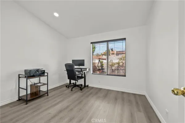 a view of a workspace with furniture and a window