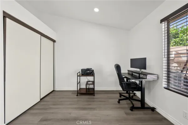 a view of a workspace with furniture and a window