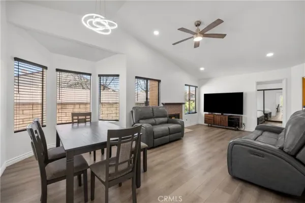 a living room with furniture kitchen view and a flat screen tv