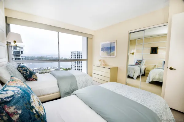 a bedroom with two beds and large window