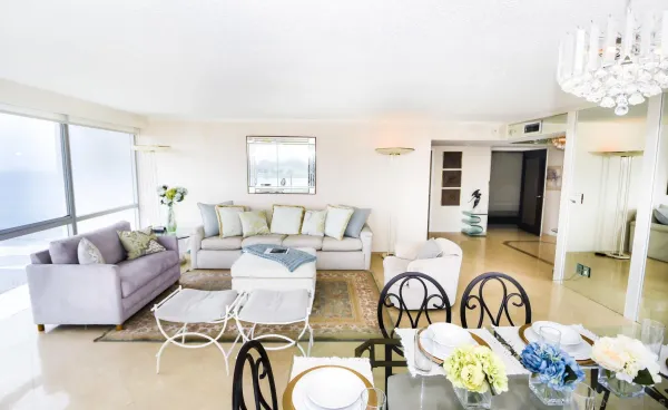a living room with patio furniture and a chandelier