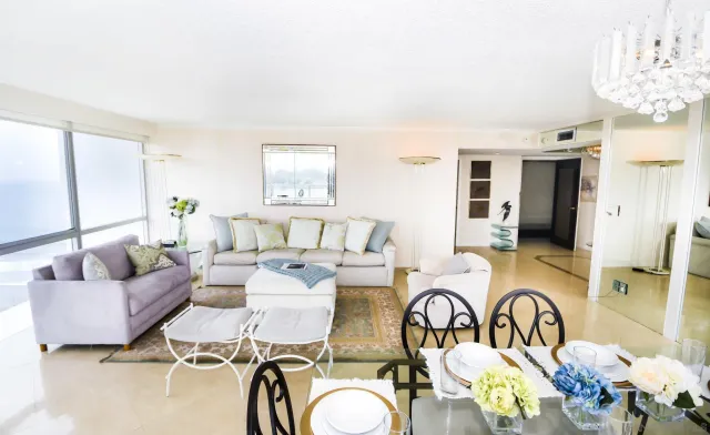 a living room with patio furniture and a chandelier