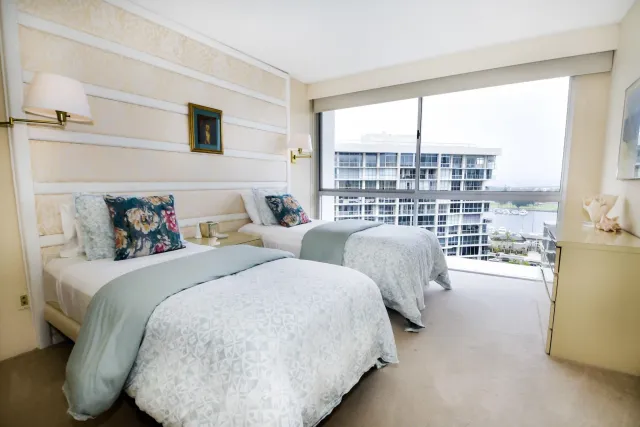 a bedroom with two beds and a large window
