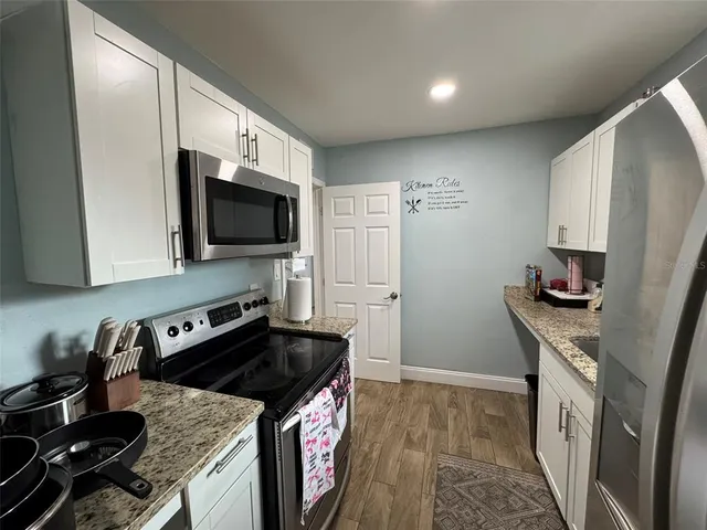 a kitchen with granite countertop a stove and a sink