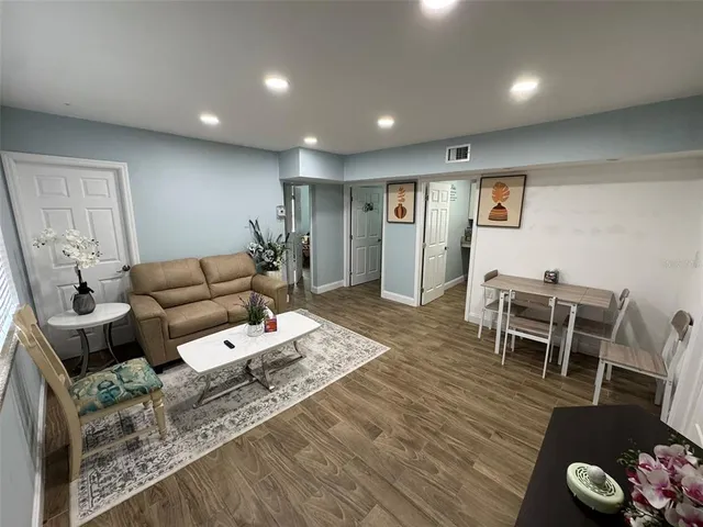 a living room with furniture and a wooden floor