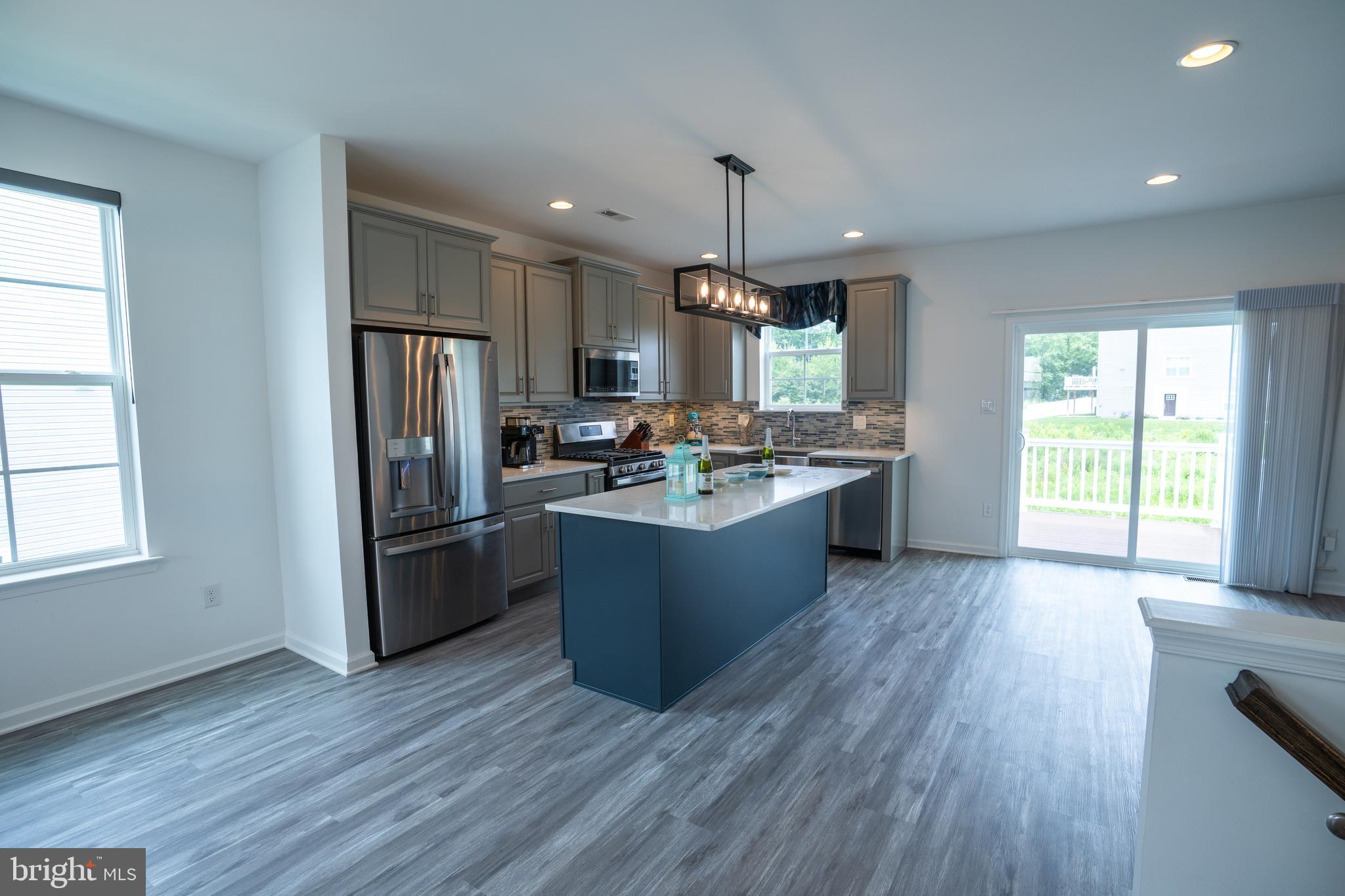 46 Aviary Road Thorofare, NJ 08086 - Photo 11 of 31 a kitchen with stainless steel appliances kitchen island wooden floors wooden cabinets and sink