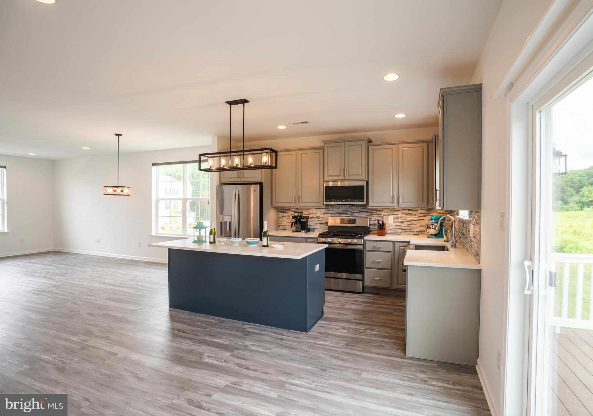 46 Aviary Road Thorofare, NJ 08086 - Photo 5 of 31 a kitchen with kitchen island granite countertop a sink cabinets and wooden floor