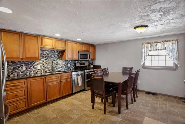 a kitchen with granite countertop sink table and chairs