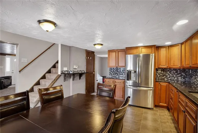 a kitchen with stainless steel appliances granite countertop a refrigerator and a stove top oven
