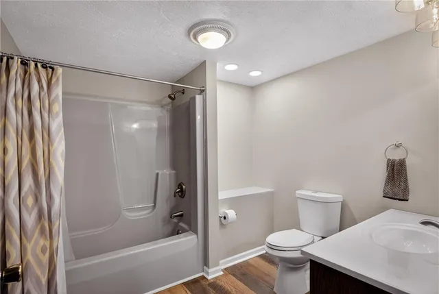 a bathroom with a shower a toilet and a sink