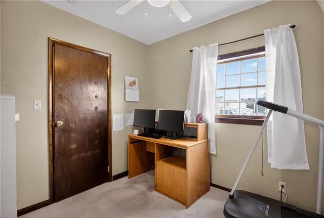 a view of a workspace with furniture and a window