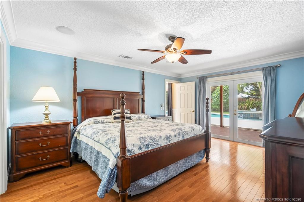 2164 Southeast St Lucie Boulevard Stuart, FL 34996 - Photo 29 of 60 a bedroom with a large bed and a chandelier