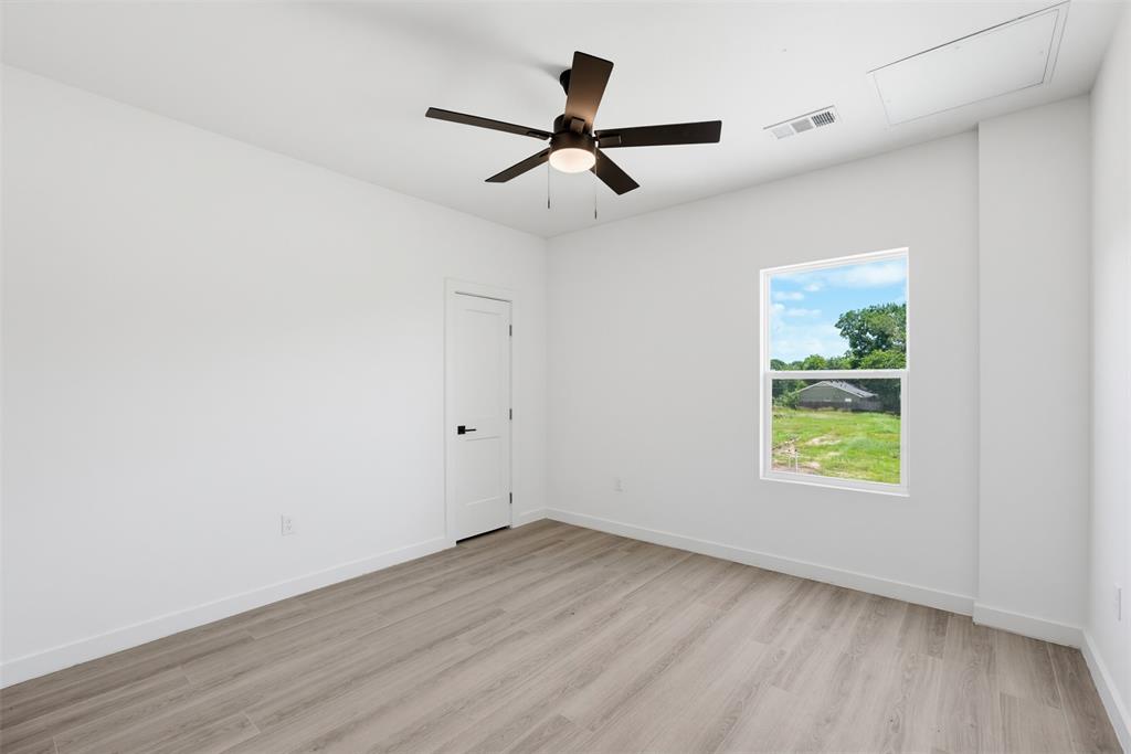 512 South O Connor Road Irving, TX 75060 - Photo 9 of 21 Room featuring wood-finish flooring, a white interior door with matte black hardware, a ceiling fan with integrated lighting, and a single window with white trim