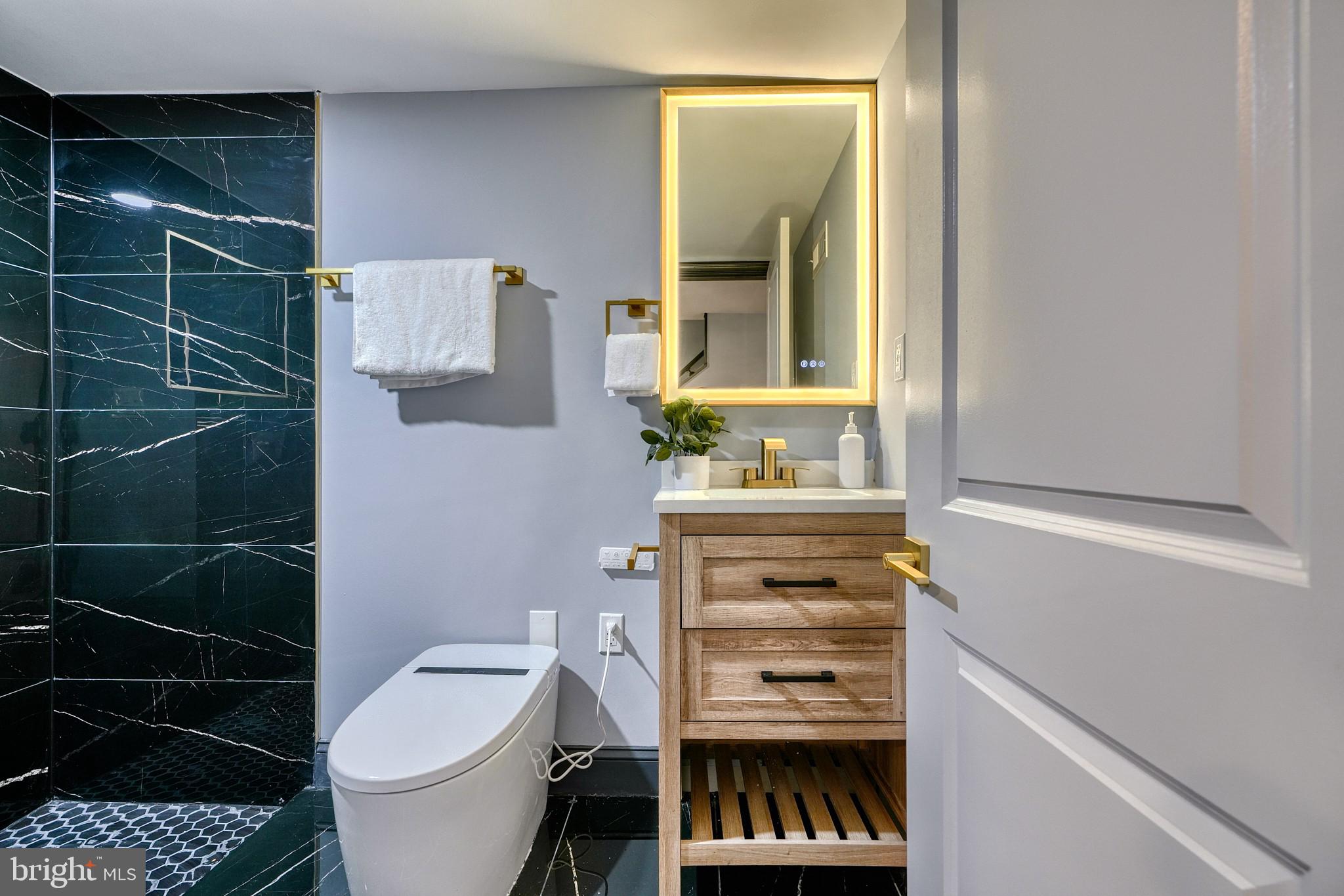 5012 Belair Road Baltimore, MD 21206 - Photo 48 of 61 a bathroom with a toilet a sink and a mirror