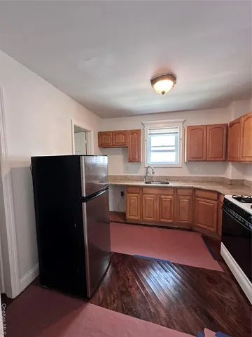 a kitchen with granite countertop a refrigerator and a stove top oven