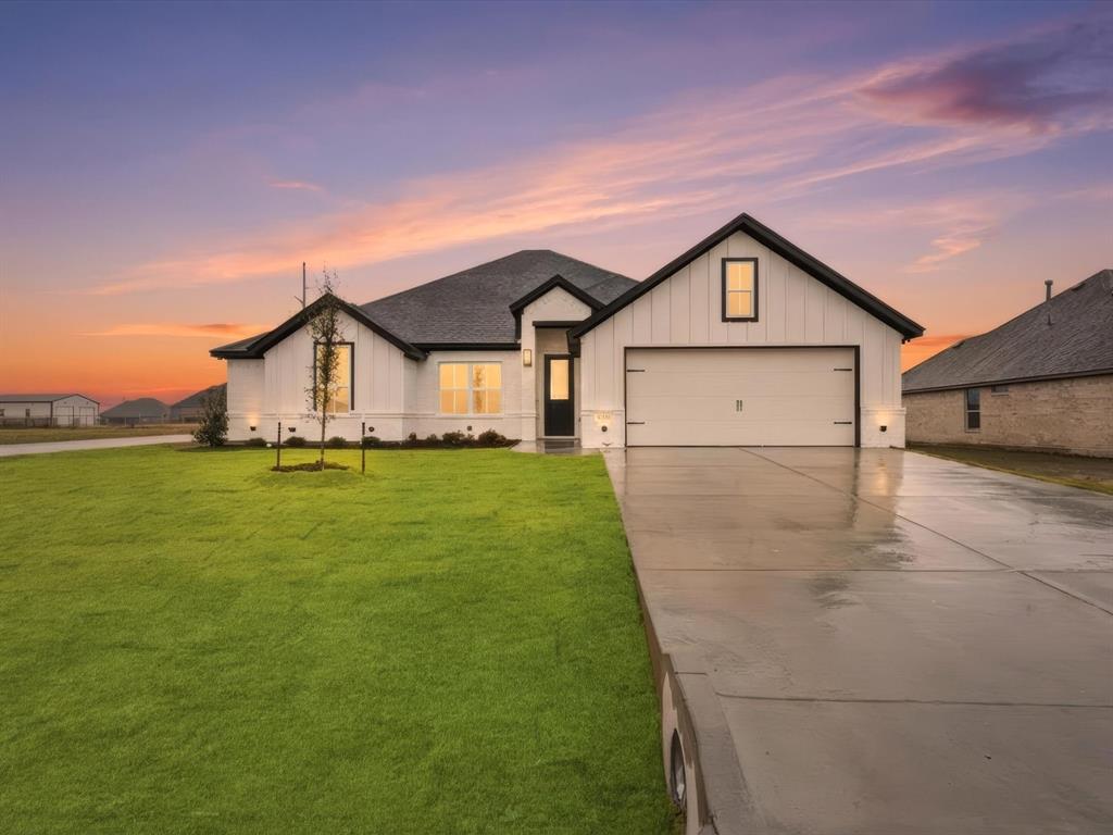 a view of a house with a big yard potted plants and large tree
