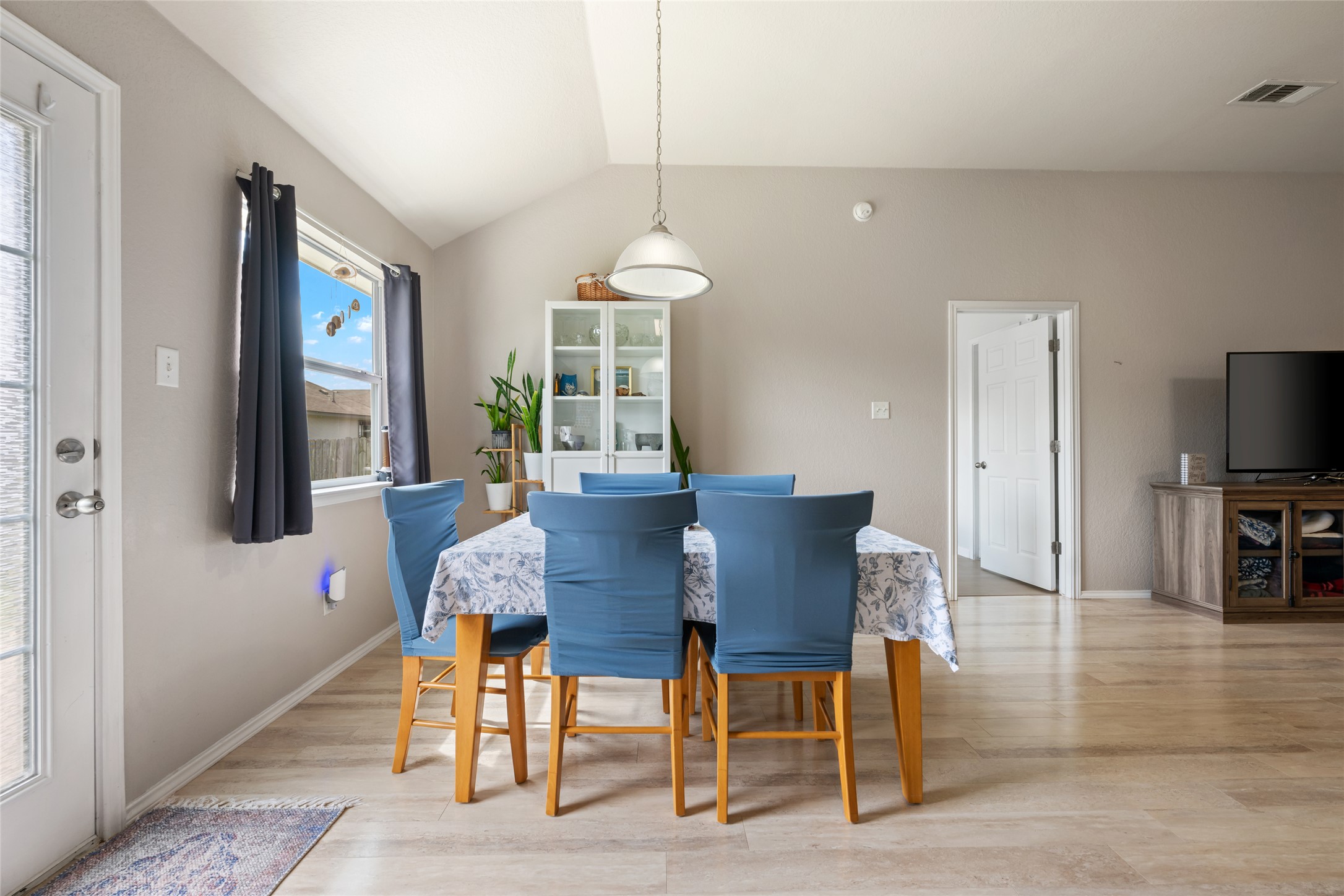 144 Calcite Lane Jarrell, TX 76537 - Photo 10 of 38 A welcoming dining area offers a light wood floor and vaulted ceilings, perfect for gathering.