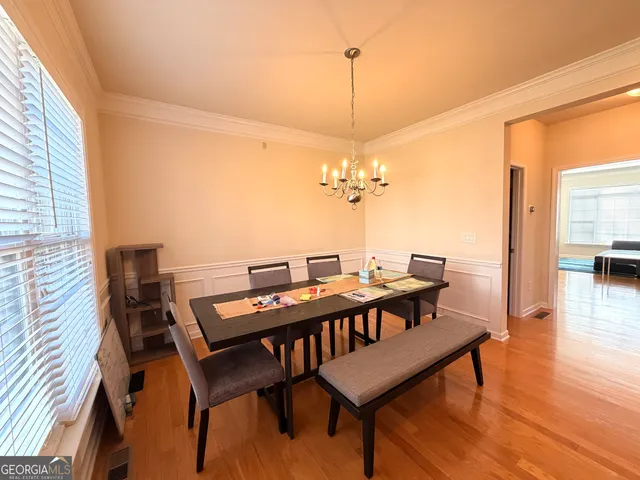 a view of a dining room with furniture wooden floor and chandelier