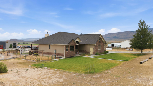 2567 West Rim Rock Drive Stockton, UT 84071 - Photo 54 of 64 Single-story residence featuring a combination of stucco and brick siding, a dark shingle roof, and a prominent front entrance