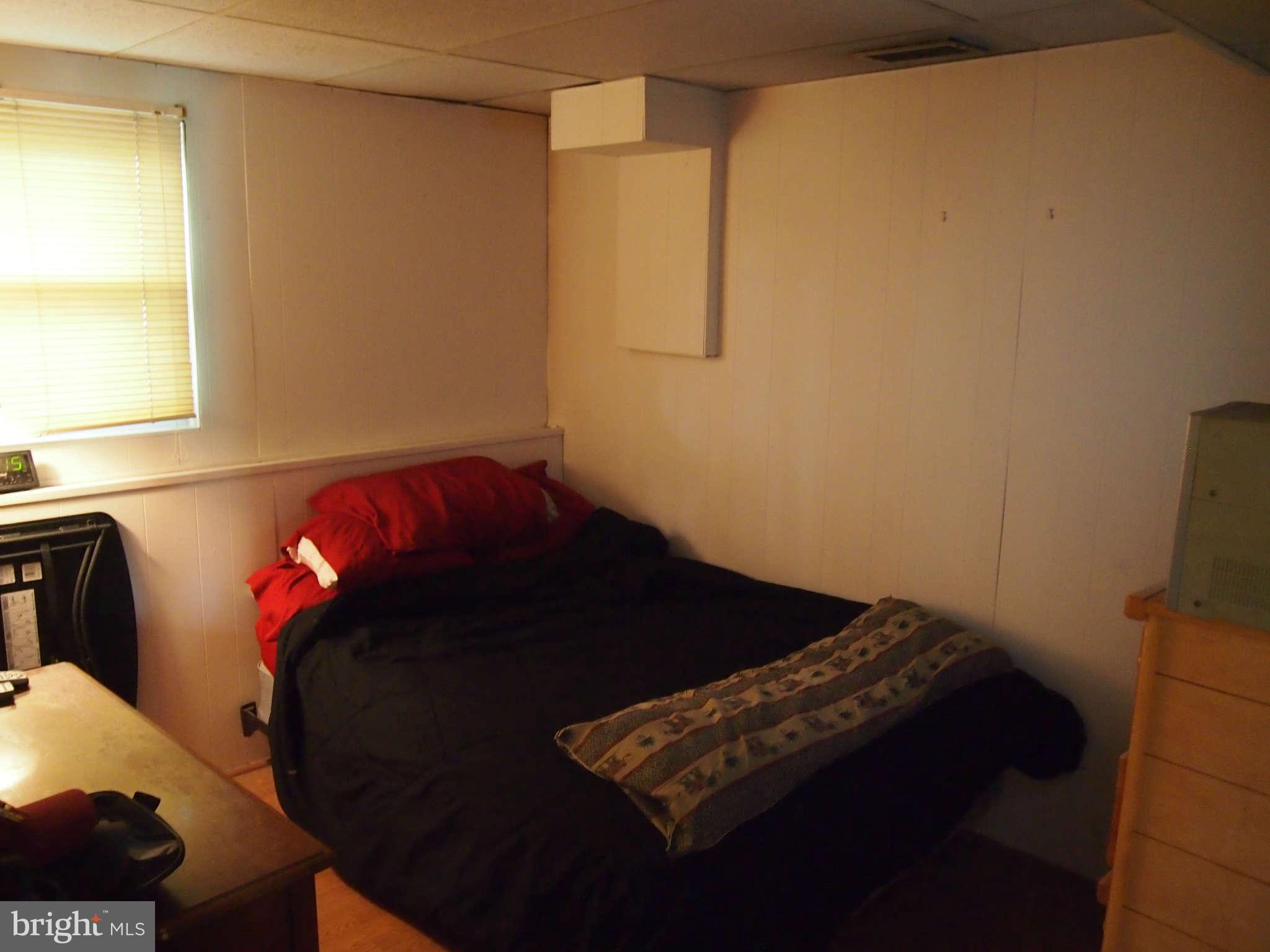 319 Holly Manor Road Baltimore, MD 21228 - Photo 13 of 17 a bedroom with a bed and a mirror