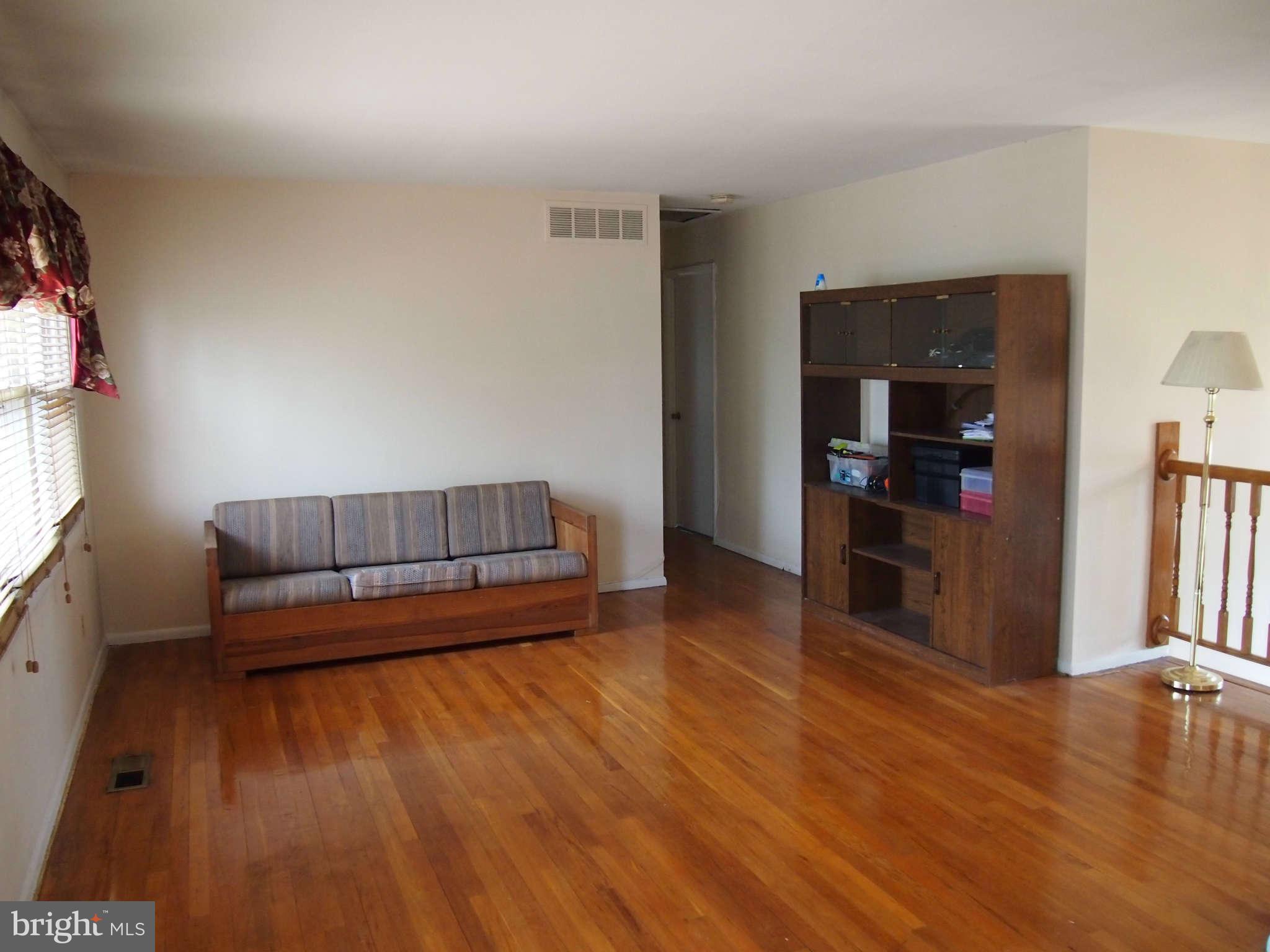 319 Holly Manor Road Baltimore, MD 21228 - Photo 3 of 17 a living room with furniture and a wooden floor