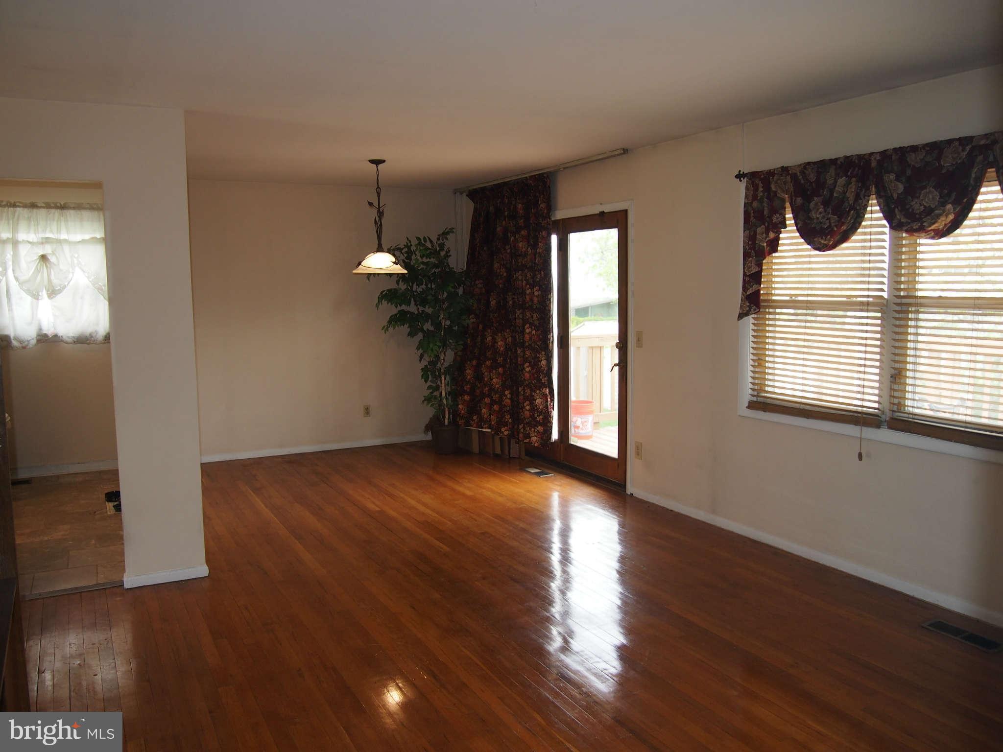 319 Holly Manor Road Baltimore, MD 21228 - Photo 4 of 17 a view of an empty room with wooden floor and a window