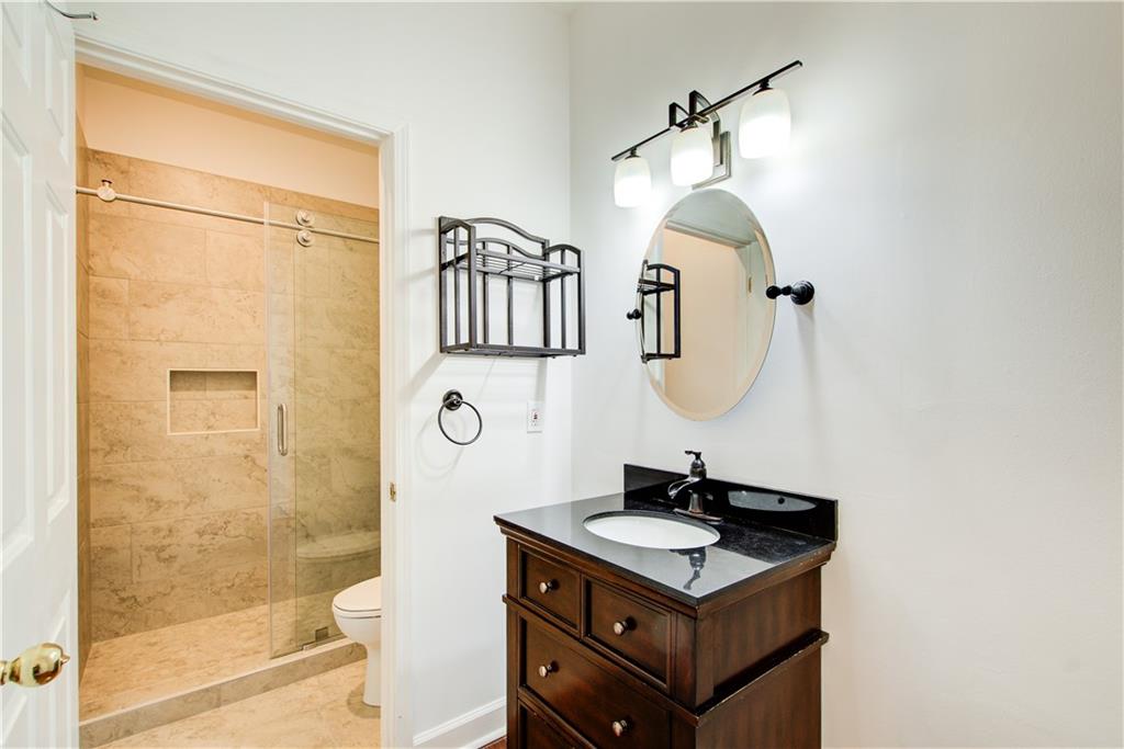 2865 Lenox Road Northeast, Unit 102 Atlanta, GA 30324 - Photo 8 of 35 a bathroom with a sink a mirror and a shower