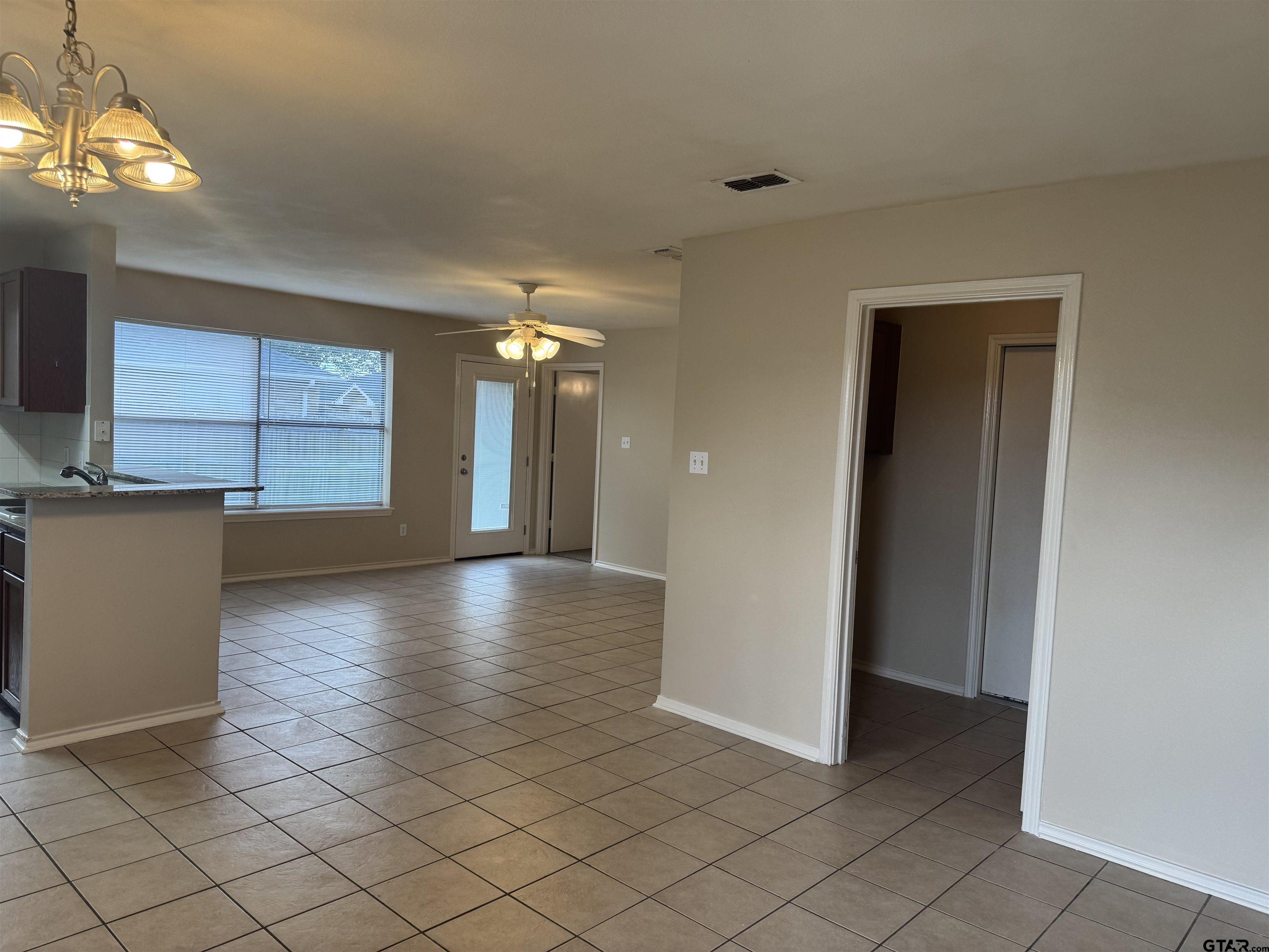 613 Hagan Road Whitehouse, TX 75791 - Photo 3 of 22 an empty room with wooden floor and windows