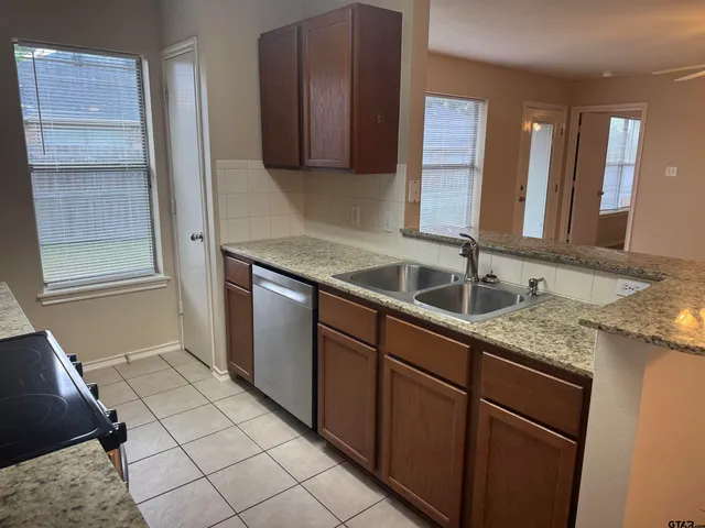 a kitchen with stainless steel appliances granite countertop a sink and a stove