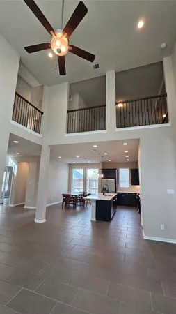 an empty room to ceiling fan and windows