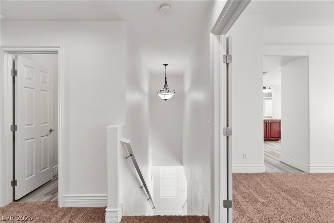 181 Short Ruff Way Las Vegas, NV 89148 - Photo 10 of 43 Corridor with an upstairs landing and light carpet