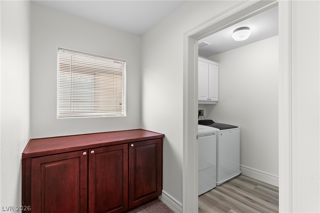 181 Short Ruff Way Las Vegas, NV 89148 - Photo 12 of 43 Laundry area featuring separate washer and dryer, cabinet space, and light wood-style flooring