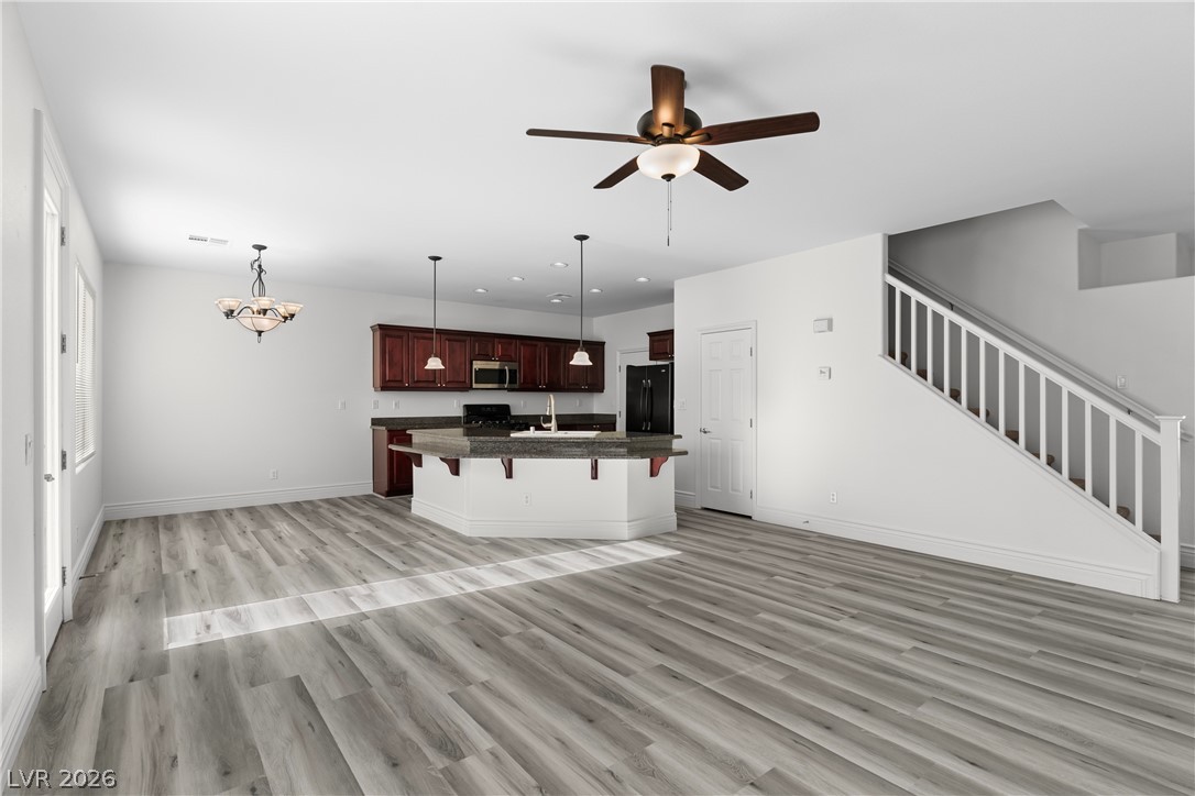 181 Short Ruff Way Las Vegas, NV 89148 - Photo 6 of 43 Unfurnished living room featuring a ceiling fan, a chandelier, and light wood finished floors