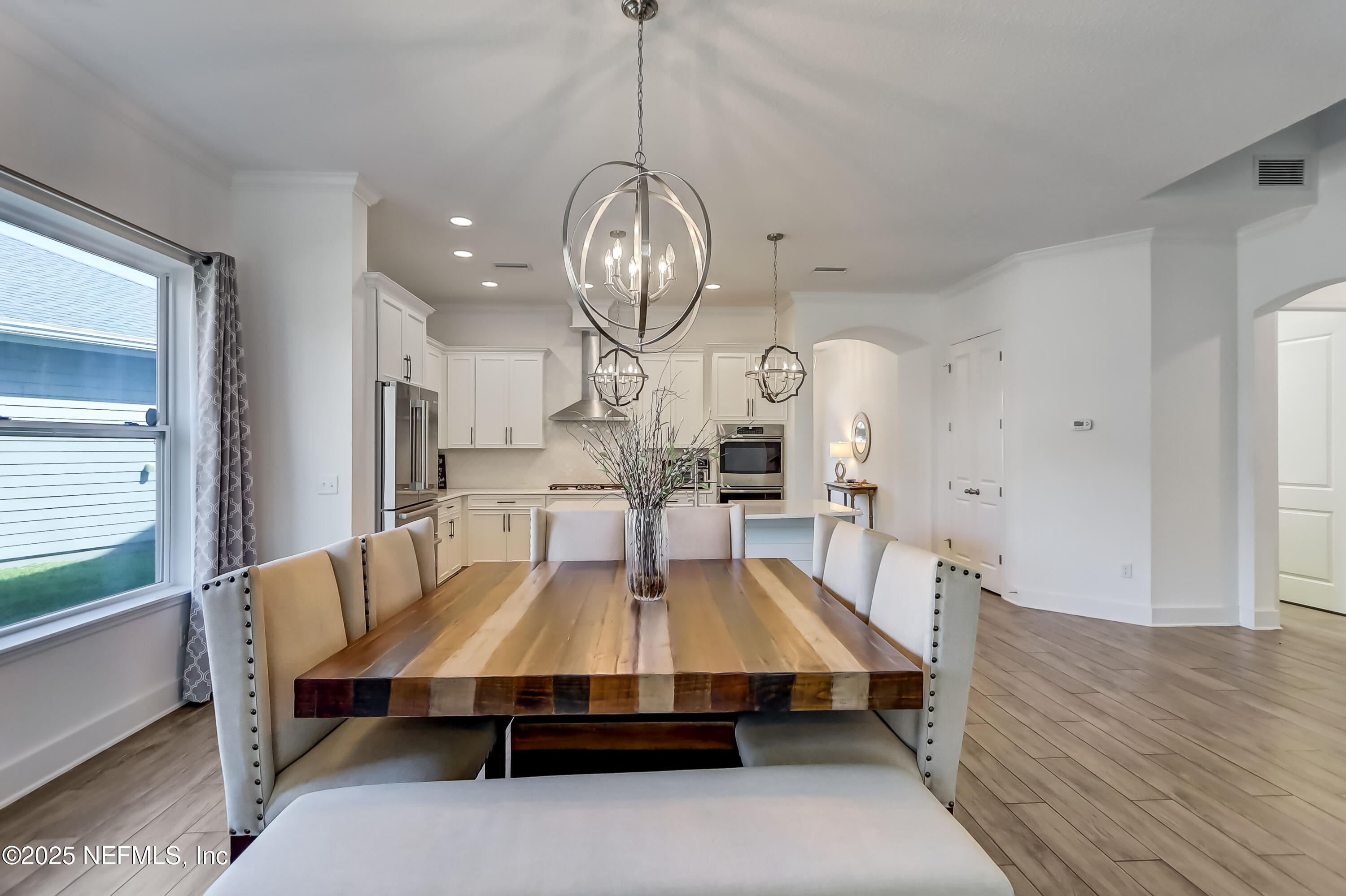 385 Daniel Park Circle Ponte Vedra, FL 32081 - Photo 21 of 34 a dining room with wooden floor a chandelier a wooden table and chairs