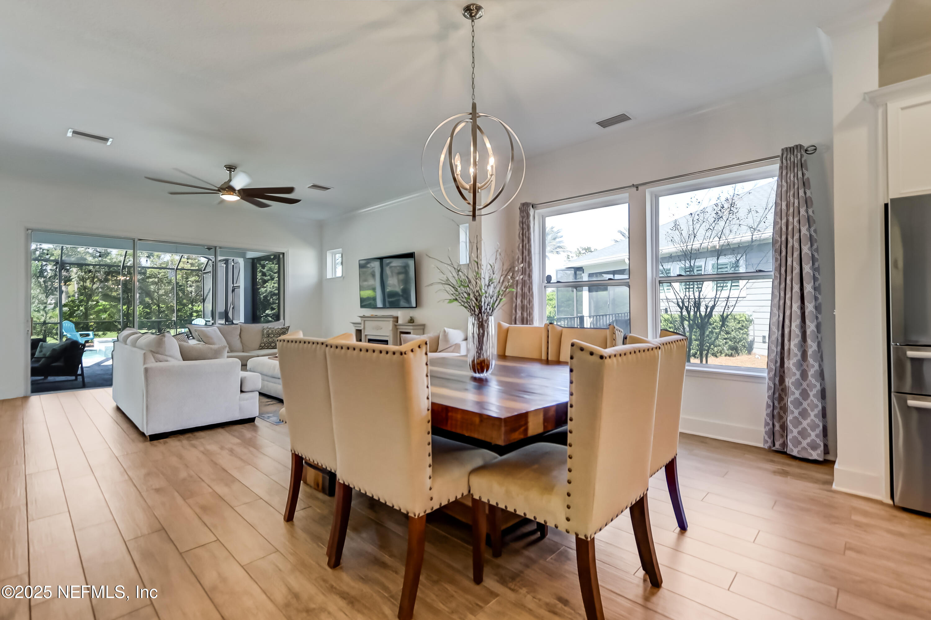 385 Daniel Park Circle Ponte Vedra, FL 32081 - Photo 22 of 34 a dining room with wooden floor a chandelier a glass table and chairs
