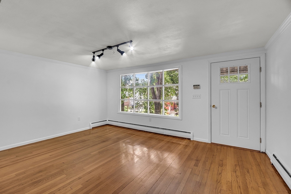 36 Mill Street Maynard, MA 01754 - Photo 18 of 42 an empty room with wooden floor and windows