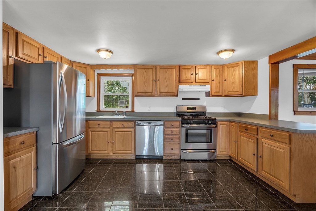 36 Mill Street Maynard, MA 01754 - Photo 10 of 42 a kitchen with granite countertop a refrigerator stove top oven and sink