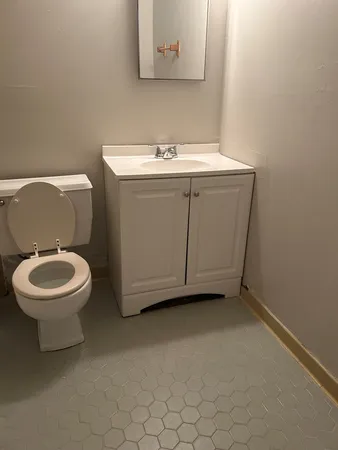 a bathroom with a toilet a sink and mirror