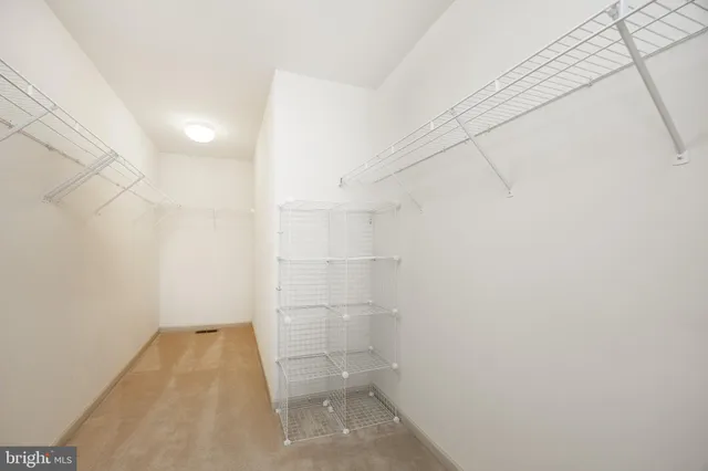 an empty room with ceiling fan and window