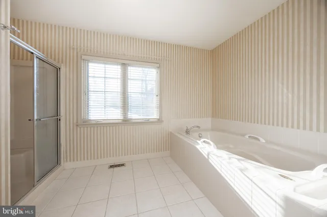 a spacious bathroom with a bathtub and shower