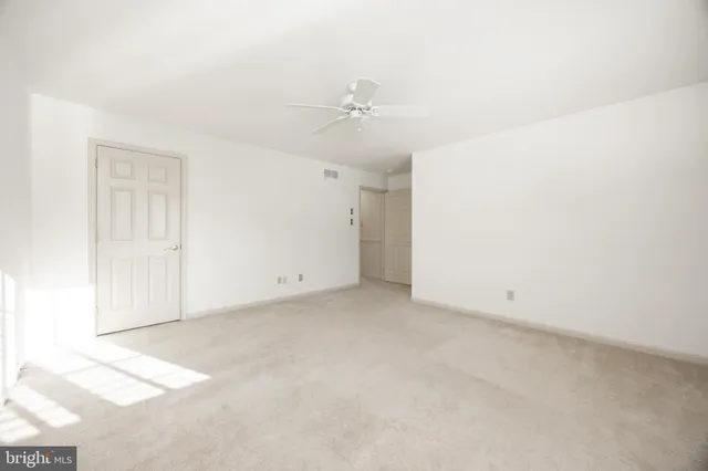 an empty room with a ceiling fan and a window