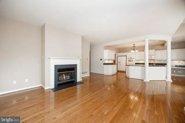 a view of kitchen livingroom with wooden floor and a fireplace