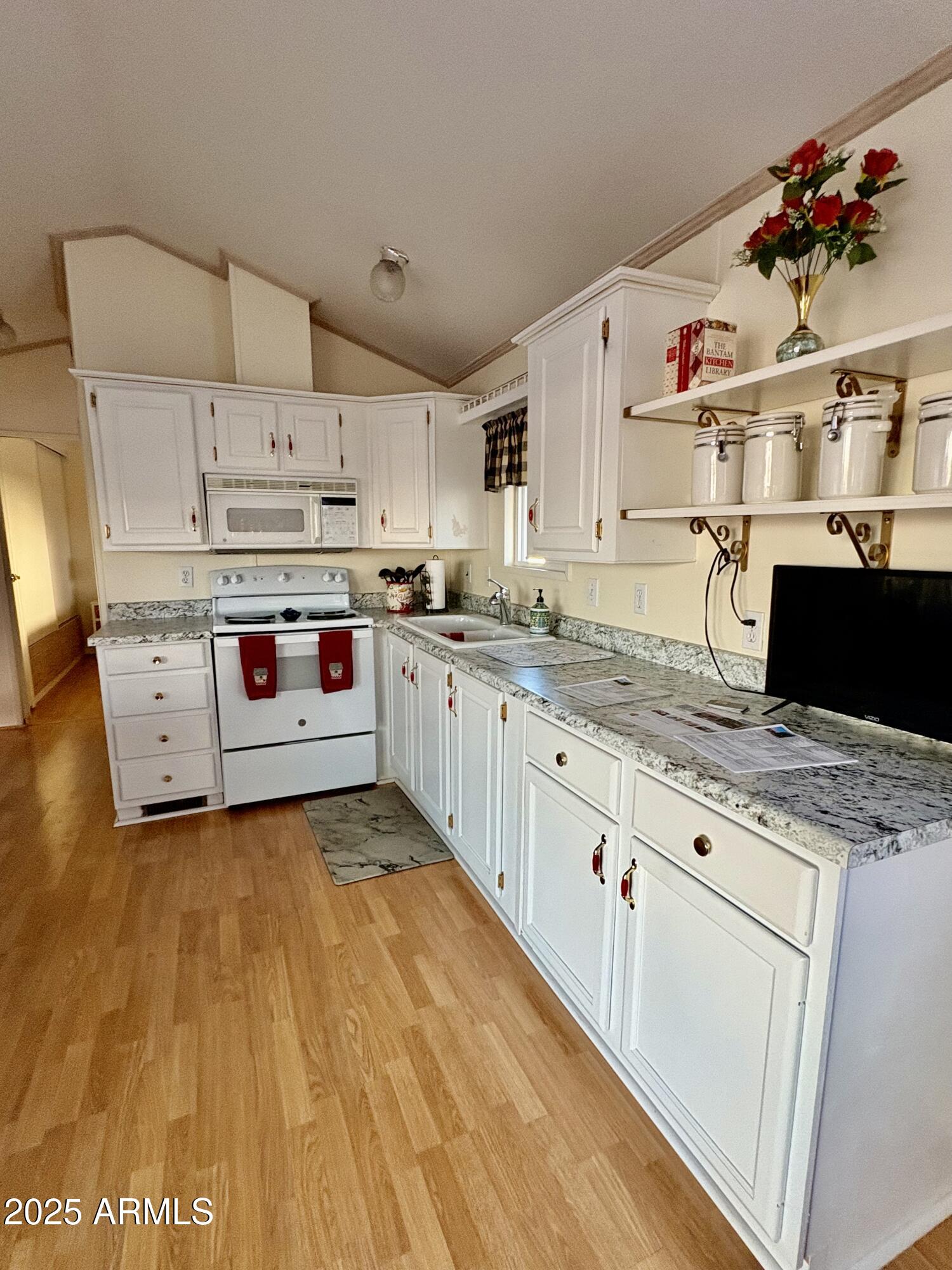 7750 East Broadway Road, Unit 604 Mesa, AZ 85208 - Photo 9 of 11 a kitchen with stainless steel appliances granite countertop a sink and cabinets
