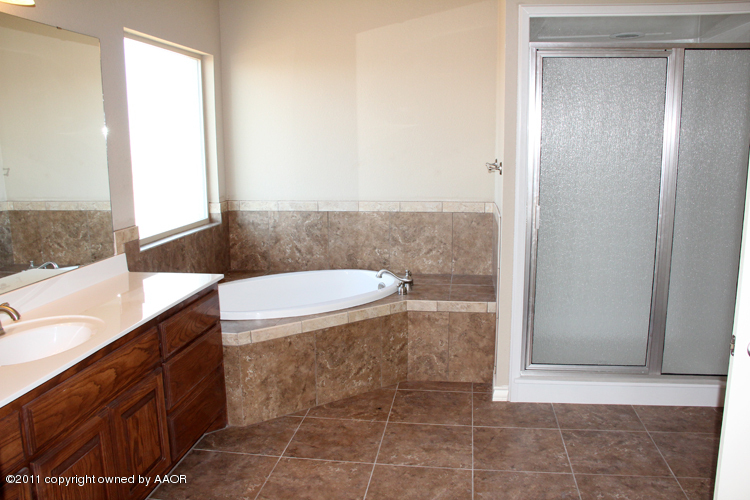 18451 Grasslands Road Bushland, TX 79124 - Photo 19 of 39 a bathroom with a granite countertop sink a toilet and a mirror