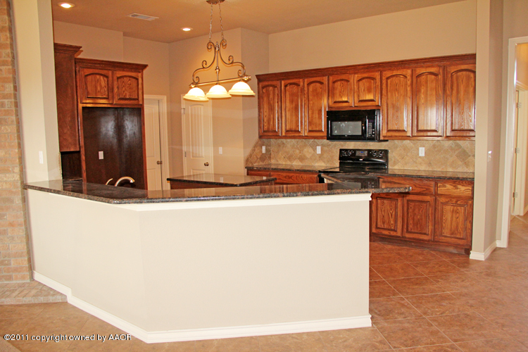 18451 Grasslands Road Bushland, TX 79124 - Photo 9 of 39 a kitchen with kitchen island granite countertop a stove top oven a sink and dishwasher