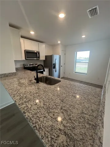 a kitchen with sink refrigerator and microwave