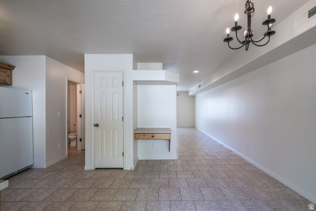 1735 West 540 North, Unit 1805 St. George, UT 84770 - Photo 36 of 64 Spacious interior with tile flooring throughout, featuring a built-in wood-finish desk, a white paneled door, and an ornate black chandelier