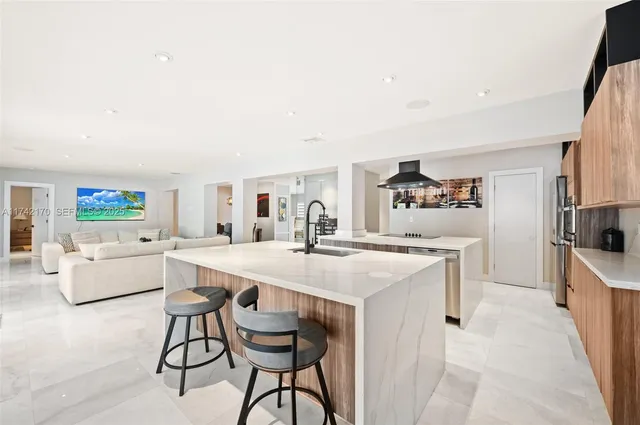 a kitchen with stainless steel appliances granite countertop a sink and a refrigerator