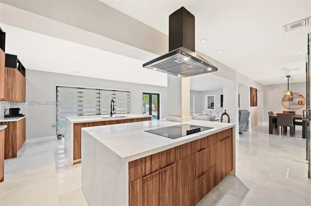 a kitchen with stainless steel appliances kitchen island granite countertop a stove and a refrigerator